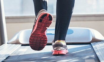 The feet of a person exercising on a treadmill