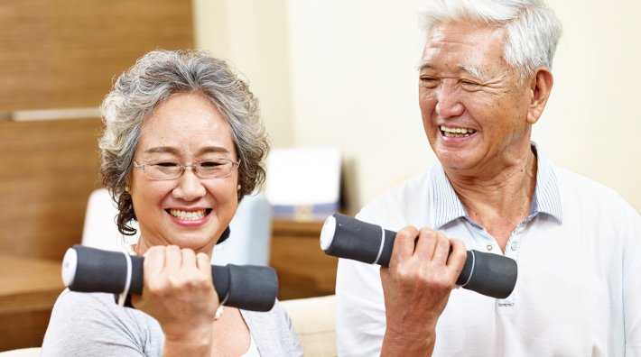 happy senior couple exercising with hand weights