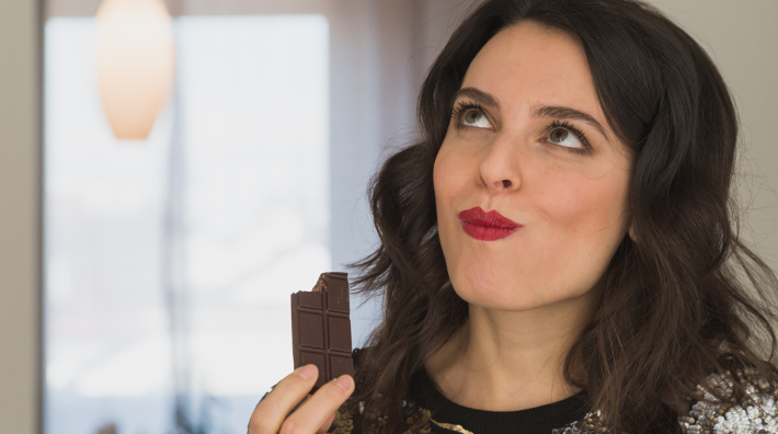 close up of woman's face as she enjoys a bar of chocolate