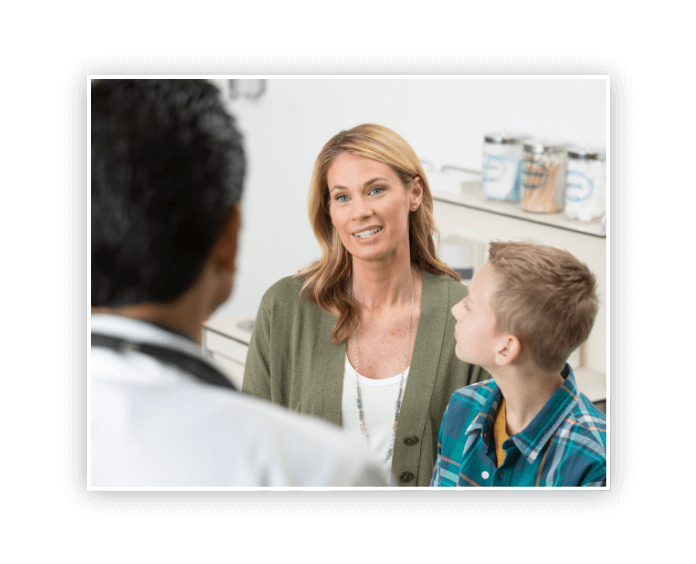 caucasian mother and son talking with doctor