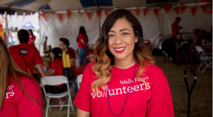 caucasian female at an event waring red volunteer shirt