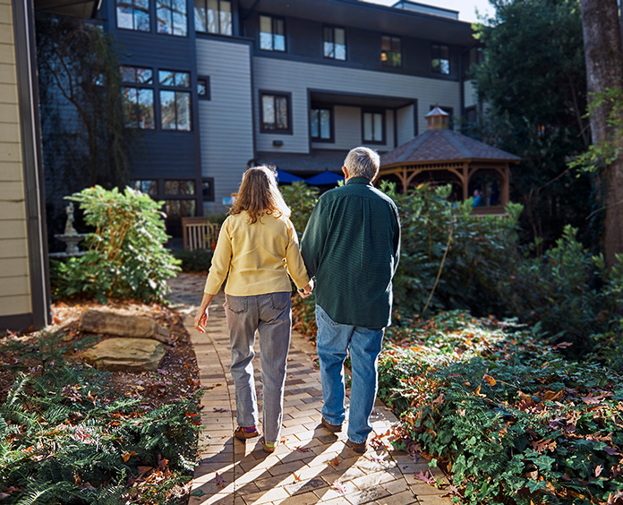white couple holding hands while walking down path at a Hope Lodge